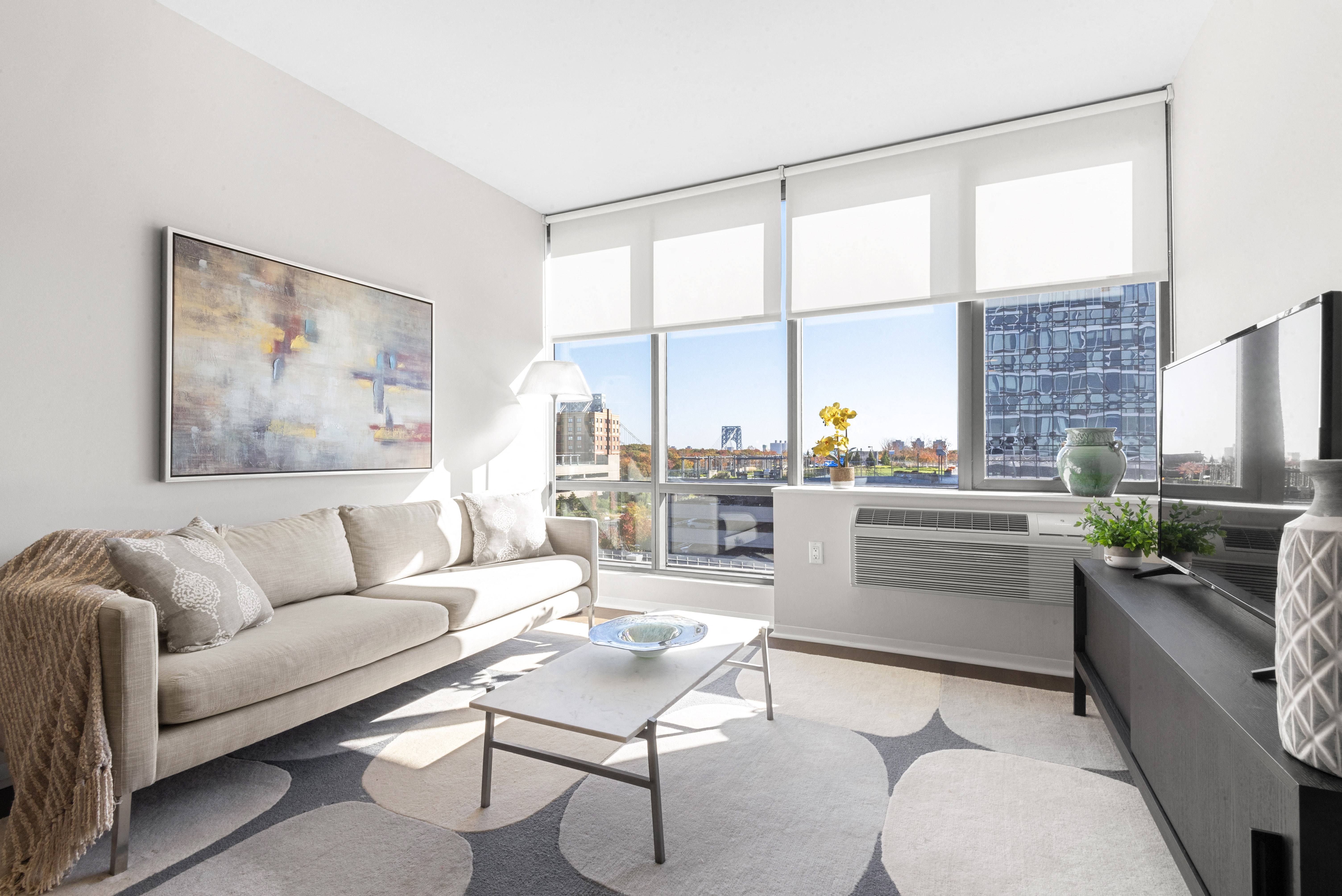a living room with a couch and a table and large windows
